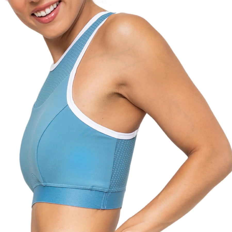 Smiling woman wearing blue patented femtech sports bra with moisture control and cooling technology