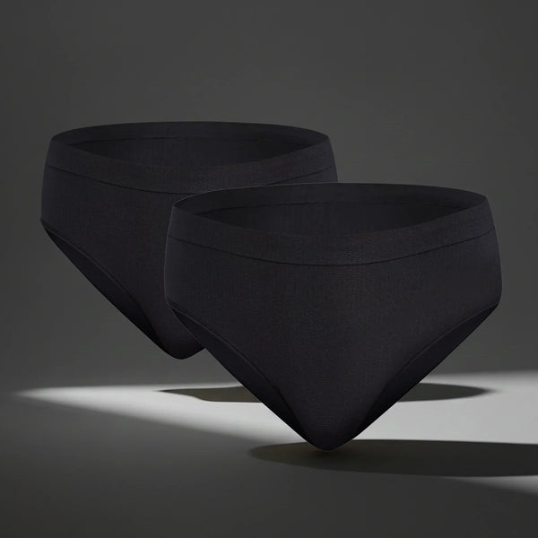 Two black seamless women's underwear briefs floating on gray background