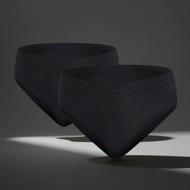 Two black seamless women's underwear briefs floating on gray background